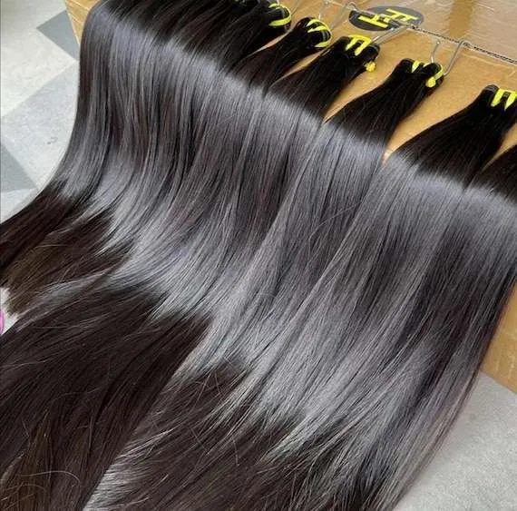 Multiple bundles of long, silky straight black hair extensions with a high-shine finish, neatly displayed.